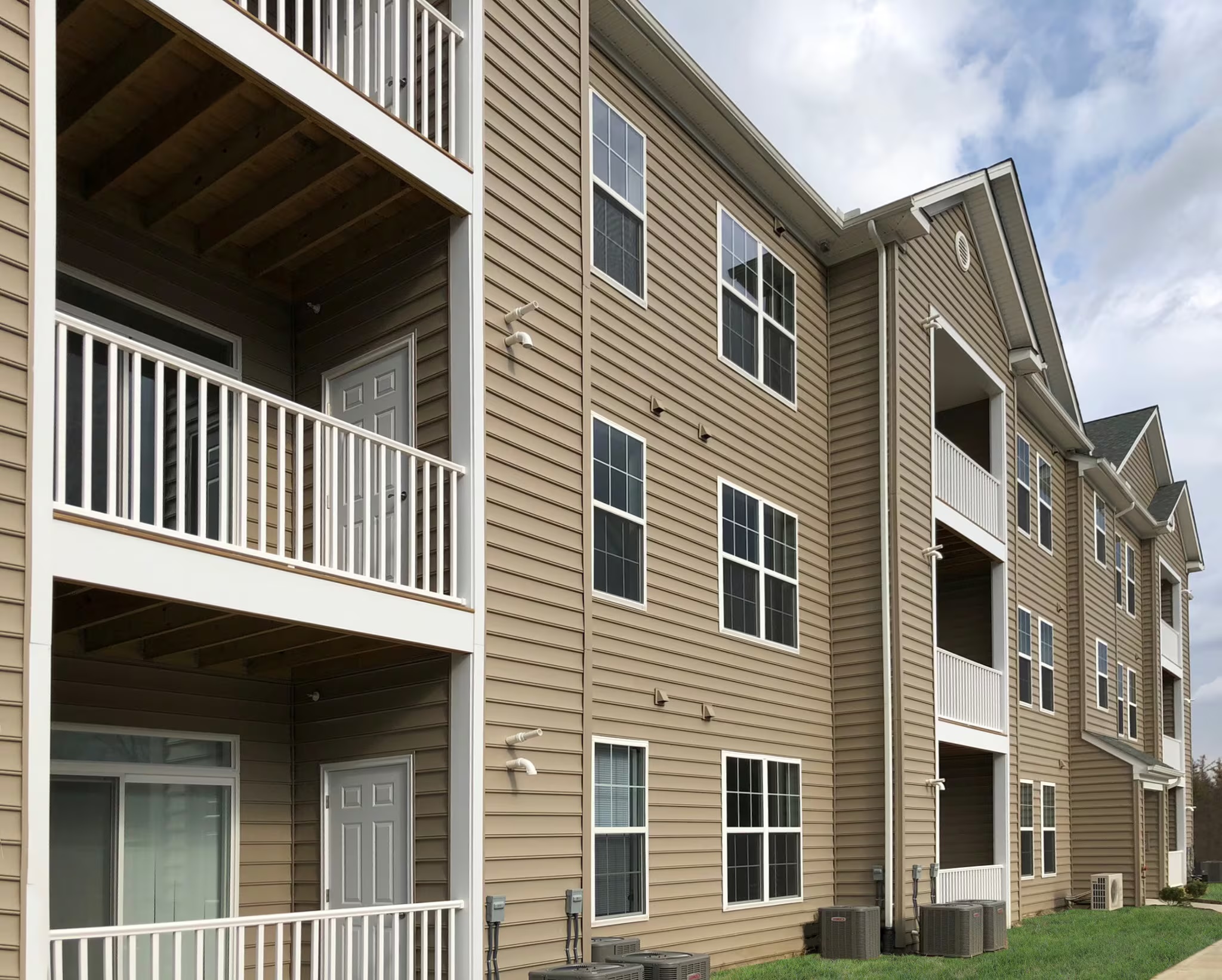Exterior of the Lexington Commons building with private balconies and tan siding